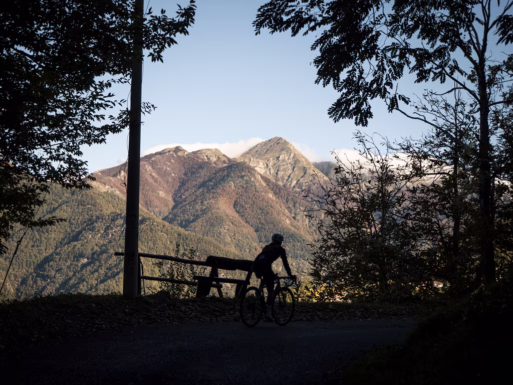 Silhouette of a cyclist with Montefegatesi in the background.