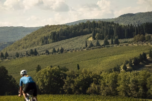 Female cyclist riding through picturesque hillside in Florence, Tuscany.