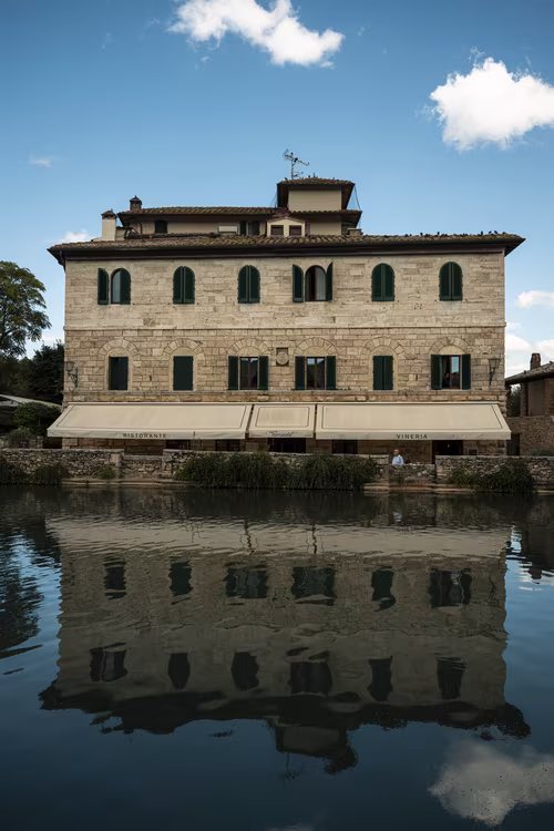 Building and its reflection in the bath of Bagno Vignoni, Tuscany. 