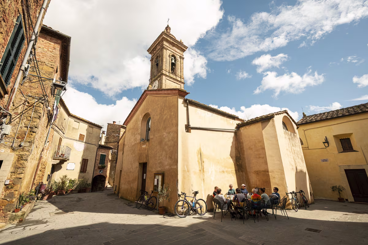 Group of cyclists stopping for coffee in Castelmuzio, Tuscany.